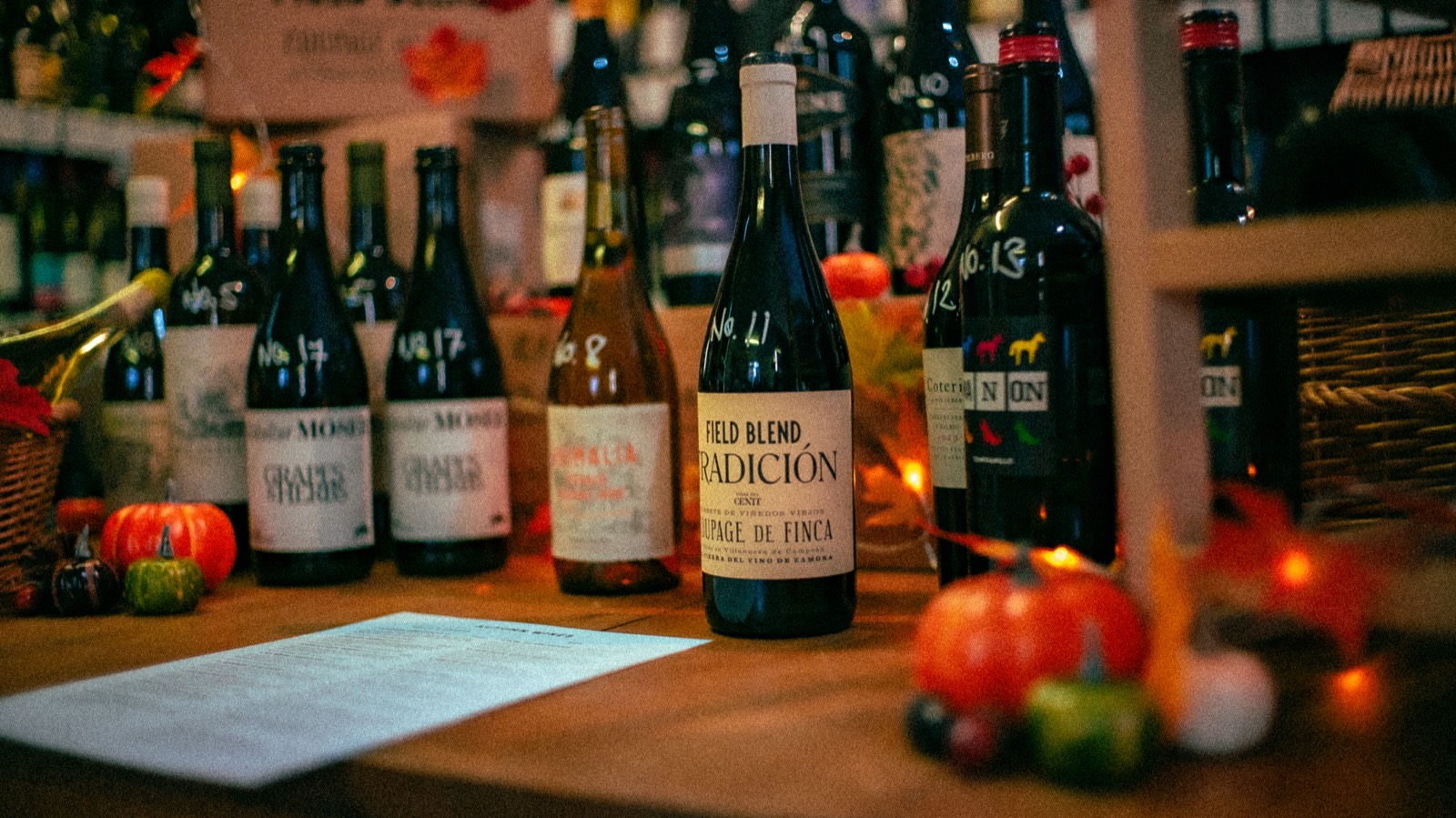 Bottles of red and white wine lined up on a wooden table